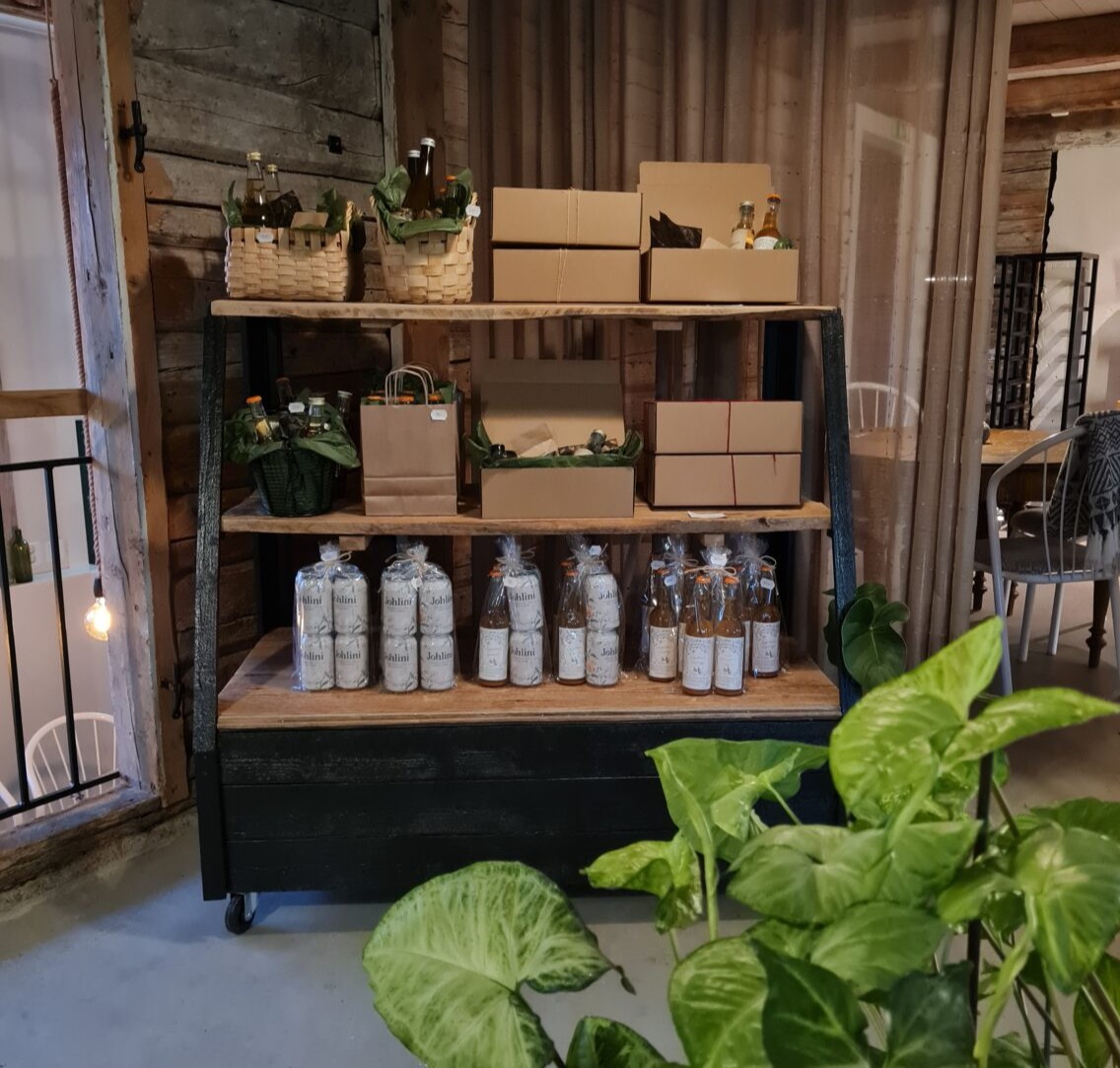 Gårdsbutik på Berghem Östergård i Jönköping med lokala produkter och presentförpackningar på hyllor.